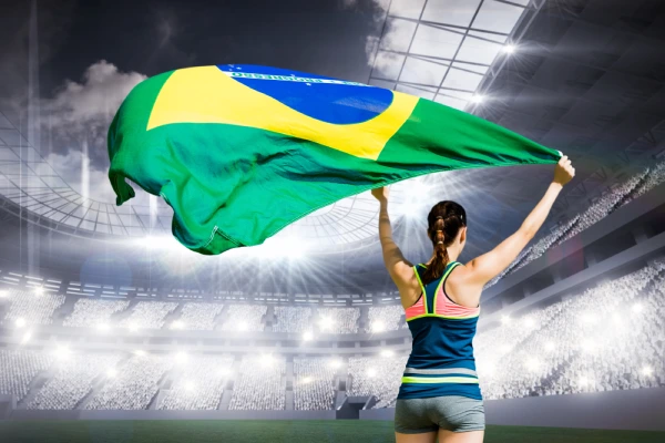 composite-image-rear-view-sportswoman-raising-brazilian-flag